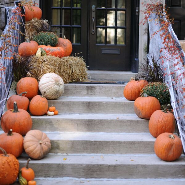 Spooky DIY Halloween front porch decorated with pumpkins and spiderwebs