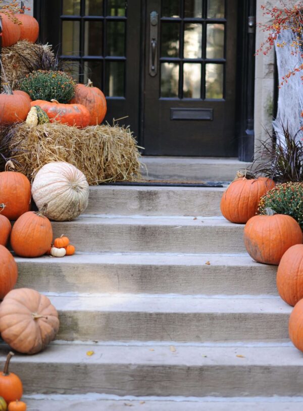 Spooky DIY Halloween front porch decorated with pumpkins and spiderwebs